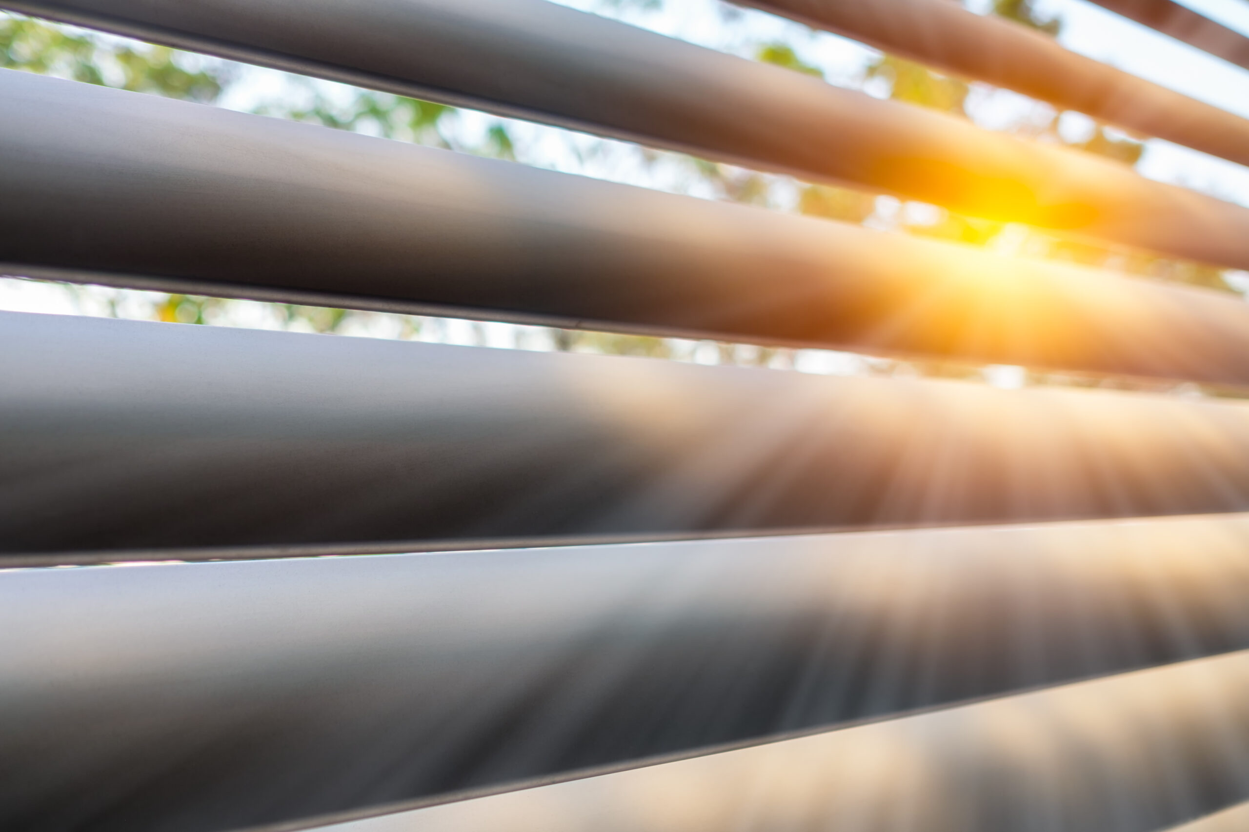 Close up of white louvres with sunlight streaming through the slats.